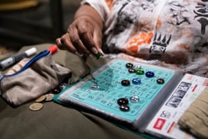 A person places tokens on a bingo card