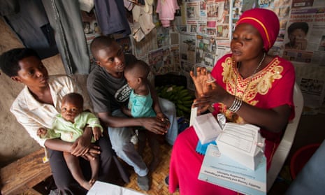 A community reproductive health volunteer gives contraceptive advice to a young family in Kasese, Uganda
