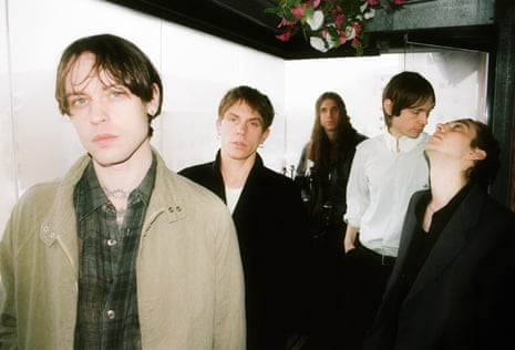 Danish band Iceage, with frontman Elias Rønnenfelt at far left, standing in front of a white screen.
