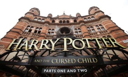 View from a low angle looking up at the frontage of an impressive old theatre, with a large sign on the front saying ‘Harry Potter and the Cursed Child, parts one and two’