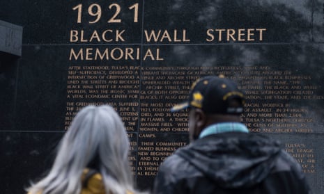 TOPSHOT-US-RACISM-MASSACRE-URBAN-PLANNING-ECONOMY<br>TOPSHOT - People look at the 1921 Black Wall Street Memorial on the 100 year anniversary of the Greenwood massacre in Tulsa, Oklahoma, on May 31, 2021. - A century ago, in the southern US town, the arrest of a young Black man accused of assaulting a white woman sparked one of the worst outpourings of racial violence ever seen in the country. On May 31, 1921, after the arrest of Dick Rowland, hundreds of furious white people gathered outside the Tulsa courthouse, signalling to Black residents that a lynching -- a common practice at the time and until as recently as the 1960s -- was imminent. (Photo by ANDREW CABALLERO-REYNOLDS / AFP) (Photo by ANDREW CABALLERO-REYNOLDS/AFP via Getty Images)