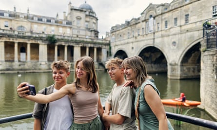 Tourist family taking selfies at the Pulteney Bridge in Bath, Somerset, United Kingdom