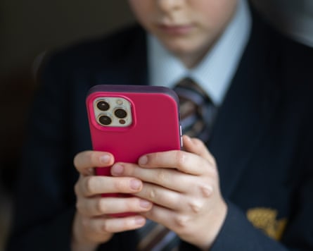 Anonymous schoolboy looking at a smartphone