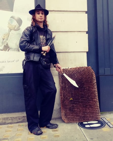 Pete Kolofsky holding a clutch of juggling knives next to a bed of nails
