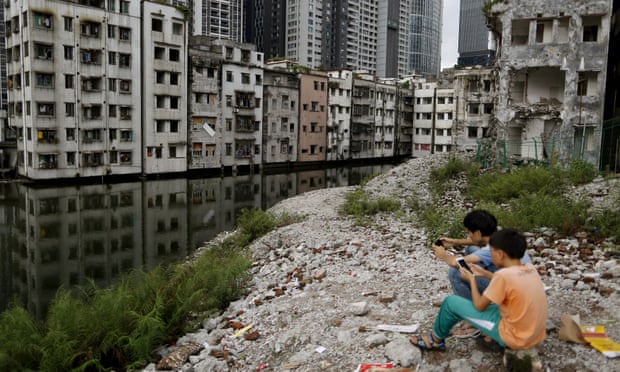 Children play among the wreckage of houses in Xian village, a slum area in downtown Guangzhou.