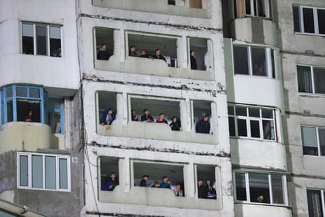 Locals watch the match from a neighbouring tower block that overlooks the Zimbru Stadium.