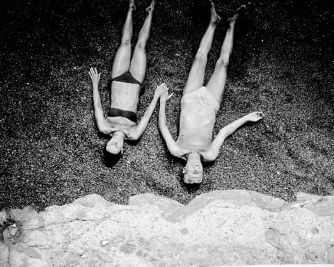 Two people holding hands on a beach, photographed from above by Marina Sersale