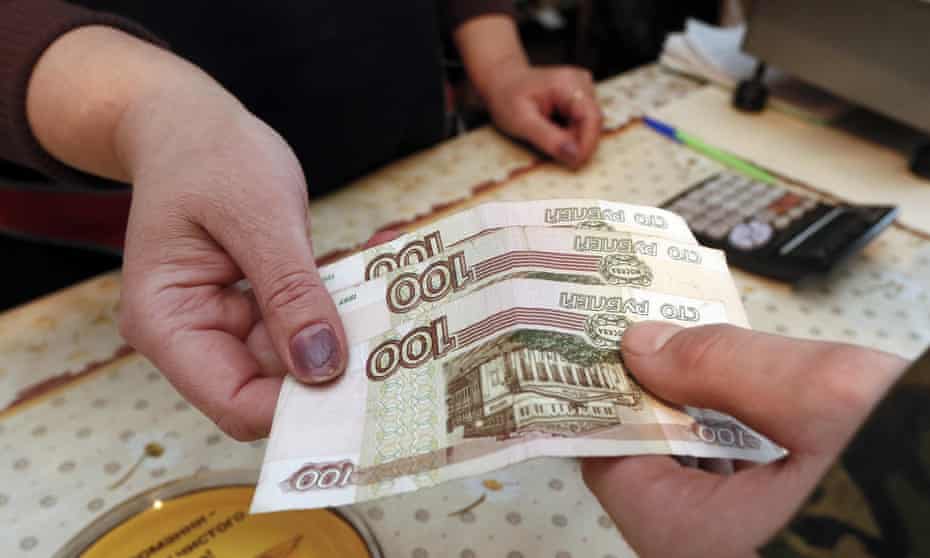A customer hands over 100-rouble banknote