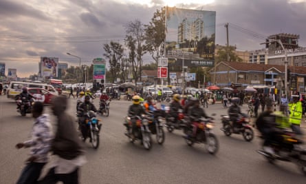 A busy road in Kenya full of people on motorbikes, many not wearing helmets