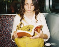 Young woman reading book in subway, shot with flash on film