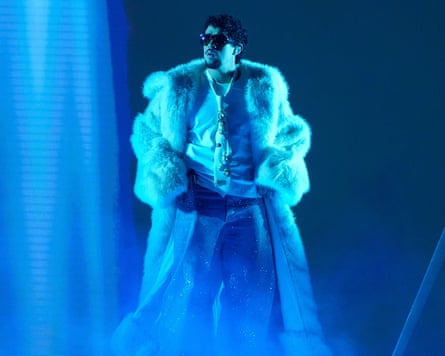 Bad Bunny on stage in a massive white fur coat