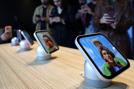 People photograph Apple HomeView smart displays on speaker stands showing portrait photos