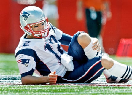 Tom Brady holds his leg after being hit by Bernard Pollard in a 2008 game.