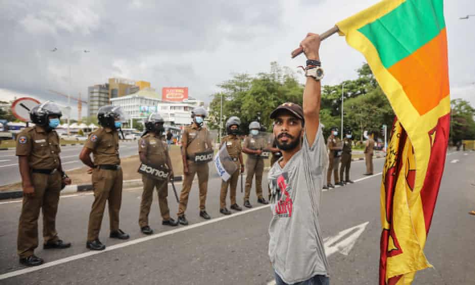 A man holds the Sri Lankan national flag during a protest in Colombo calling for the resignation of the president