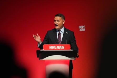 Wes Streeting stands at a lectern at the Labour party conference, behind a sign reading ‘Hope Again’, against a red backdrop