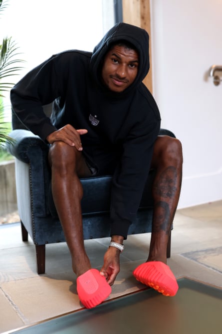 Marcus Rashford of England tries on a pair of Nike Mind footwear at Tottenham Hotspur Training Centre.