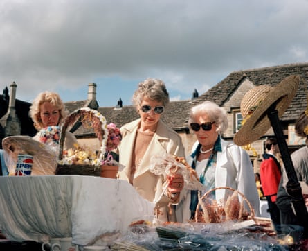 Women wearing smart clothes and sunglasses at a village fete.