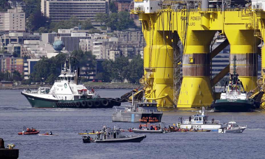 A small flotilla of kayakers and other protest boats follow as the oil drilling rig Polar Pioneer is towed toward a dock on Thursday in Elliott Bay in Seattle. 
