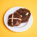 An M&S tiramisu hot cross bun, sliced, toasted and buttered, on a white plate
