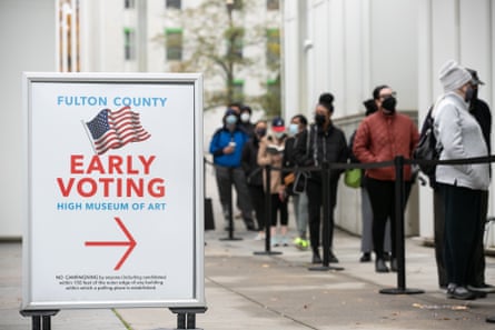 Voters line up next to an early voting sign.
