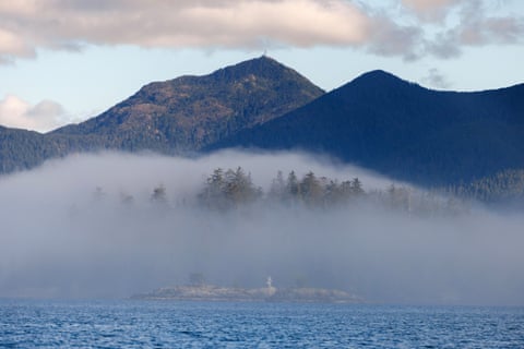 Mountains rise out of fog on a sea shore