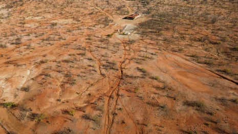 Red soil and sparse scrubby trees seen from above