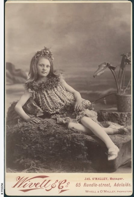 A 10-year-old girl dressed as a Sea nymph, lounging on a decorated sofa