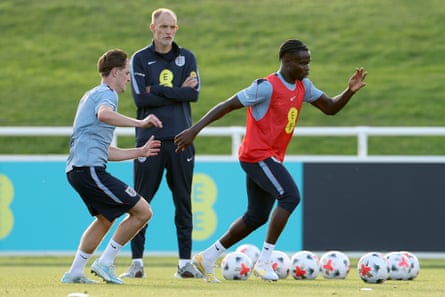 Alex Scott and Bukayo Saka battle for possession during a training session as England head coach Thomas Tuchel looks on