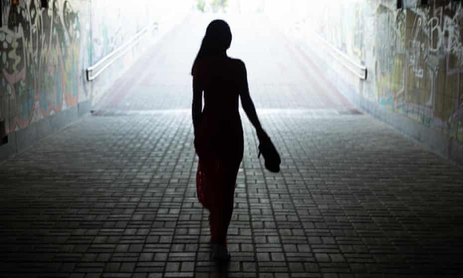 Silhouette of a girl in a long dress going to the exit from an underground pedestrian crossing.