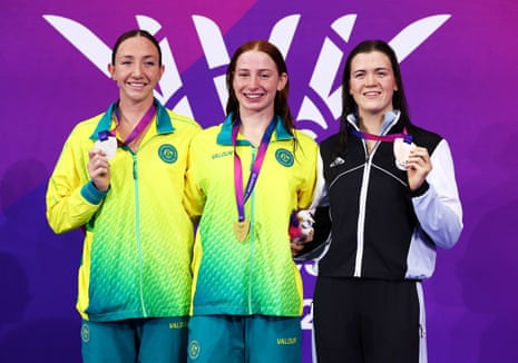 Gold medallist Mollie O'Callaghan of Australia (centre) celebrates on the podium after winning the women's 200m freestyle final with silver medallist and compatriot Lani Pallister and bronze medallist New Zealand's Erika Fairweather.