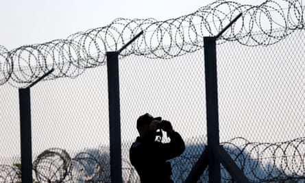 A policeman on lookout at the Hungary- Serbia border fence ... in 1989 there were 15 border walls globally; today there are 70.