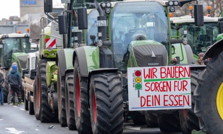 A sign reading ‘We farmers take care of your food’ hangs on a tractor parked along Bismarckstrasse in Berlin.