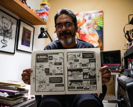 Ricardo Bobadilla holding a copy of a magazine featuring his cartoon open.
