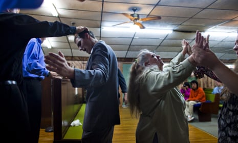 Church of the Lord Jesus member Justin Fletcher is anointed with oil as Nancy Kennedy whirls in a trance at a church in West Virginia.