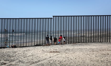 Mexicans meet separated family members through the US-Mexico border fence in Tijuana.
