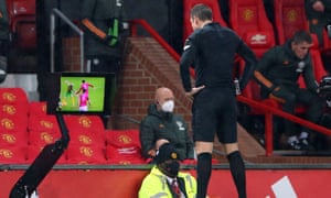 David Coote watches a replay before ruling out a penalty that he had awarded.