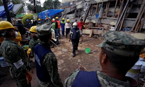 A paramedic walks towards soldiers during a search for students at the Enrique Rebsamen school after an earthquake in Mexico City