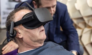 Dutch designer Alexander Bannink explains how the “Sarco” euthanasia pod works to a man via virtual reality goggles.