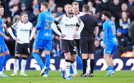 Derby County’s Joe Ward (centre) ponders his life choices after being shown a red card by referee Ben Toner for two bookable offences.