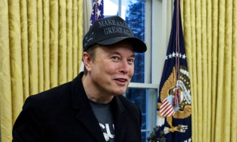 Elon Musk in the Oval Office wearing a black 'Make American Great Again' cap.