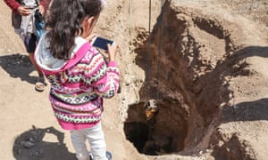 Zahara Taleb watches an unexploded bomb being removed from her father’s farmland.