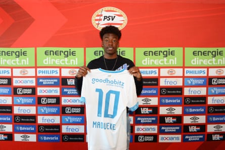 Noni Madueke holding up a PSV Eindhoven shirt