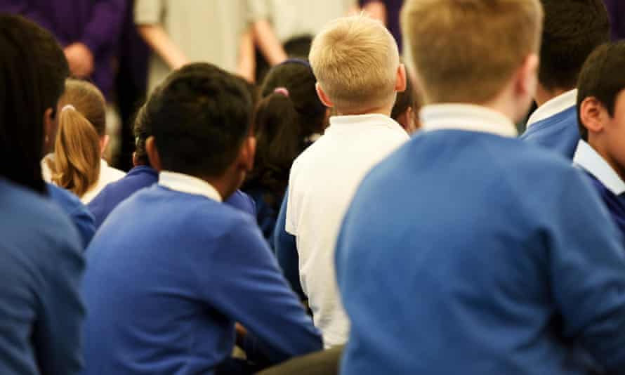 Young primary school aged children sit in a school assembly