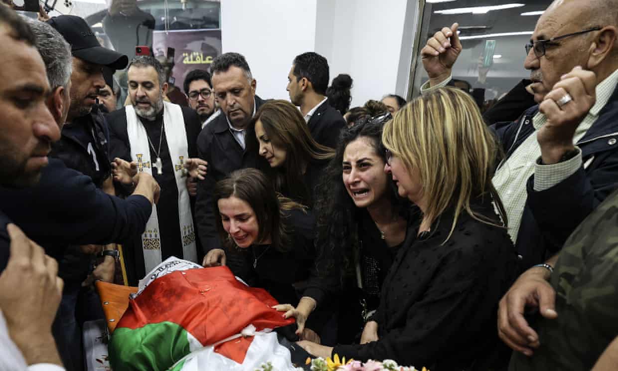 Colleagues and friends react as the Palestinian flag-draped body of Shireen Abu Akleh is brought to the news channel's office in the West Bank city of Ramallah in May.