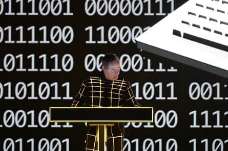 Ralf Hutter plays a synthesiser in front of a wall of numbers