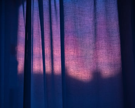 Purple sky filtering through drawn curtains.