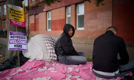 Afghan refugees Rahman Sahah (left) , 32 and Mirwais Ahmadzai, 27, sit outside the Home Office in Glasgow, Scotland, last month