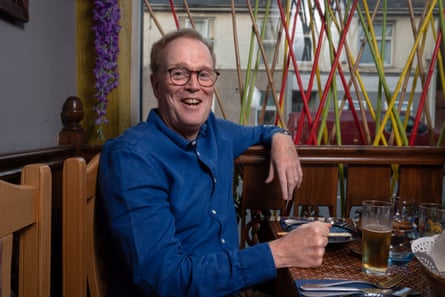 Man in blue shirt and glasses, sitting at a restaurant table