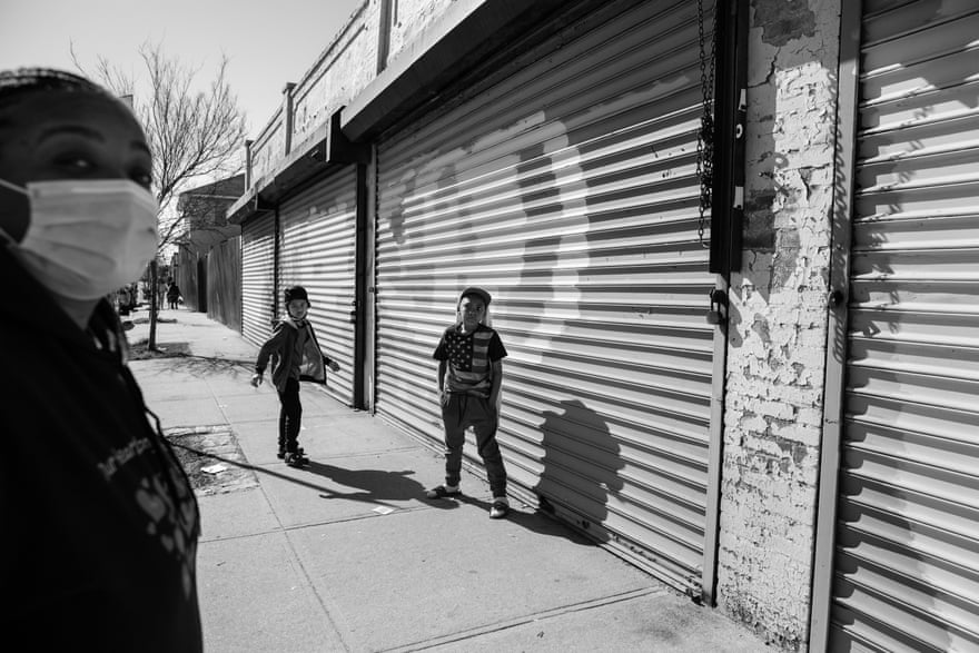 Kimberly White Smalls and her grandsons Kelsey E. Smalls Jr, 8, left, and Donovan E. Smalls, 9, right, stand outside a closed store that has still not been able to reopen after Hurricane Sandy on the corner of Beach Channel Drive and Beach 43rd Street in the Edgemere neighborhood of Far Rockaway, Queens on April 6, 2021. Smalls grew up in the neighborhood and had to flee her family home when Hurricane Sandy hit.