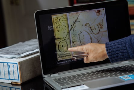 A hand points to a laptop, open with a map on the screen